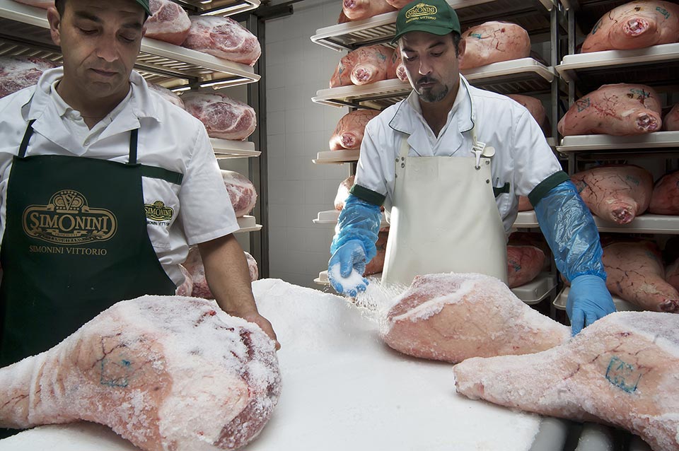 Salagione a mano dei prosciutti