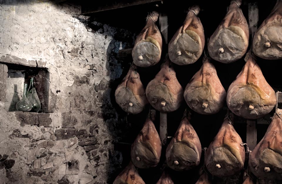 Prosciutti in stagionatura nella vecchia cantina